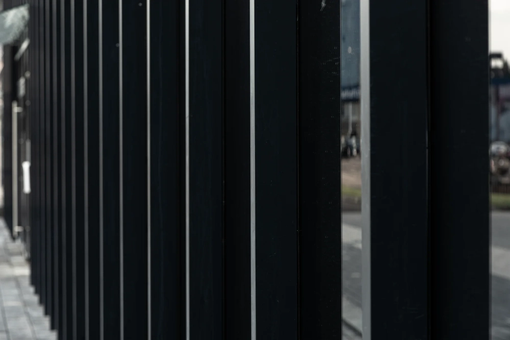 Moderner Lamellenzaun aus pulverbeschichtetem Stahl mit schwarzen vertikalen Lamellen