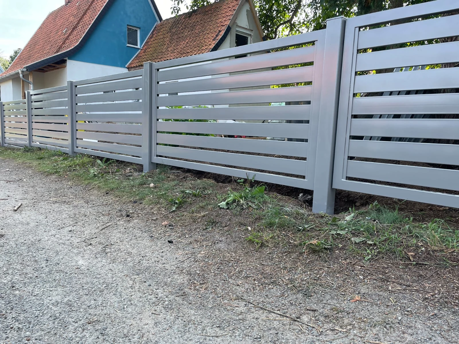 Moderne Aluminium zäune mit horizontalen Lamellen vor Wohnhäusern