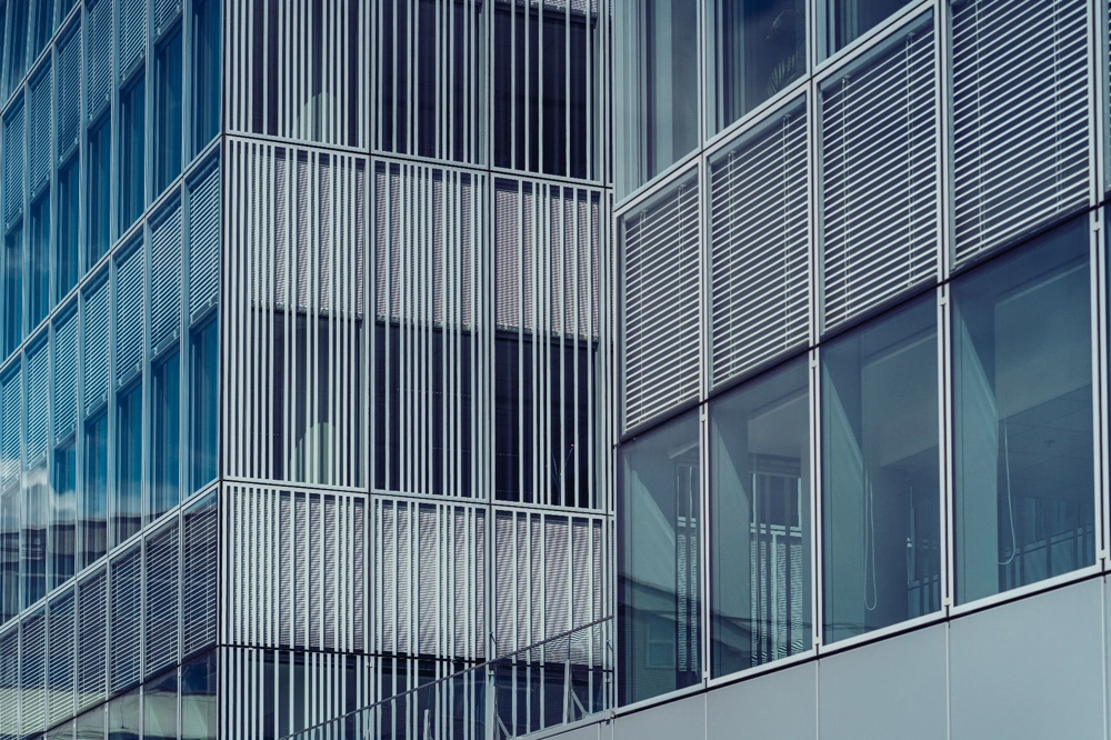 Fassade mit modernen Außenjalousien und großflächigen Fensterfronten